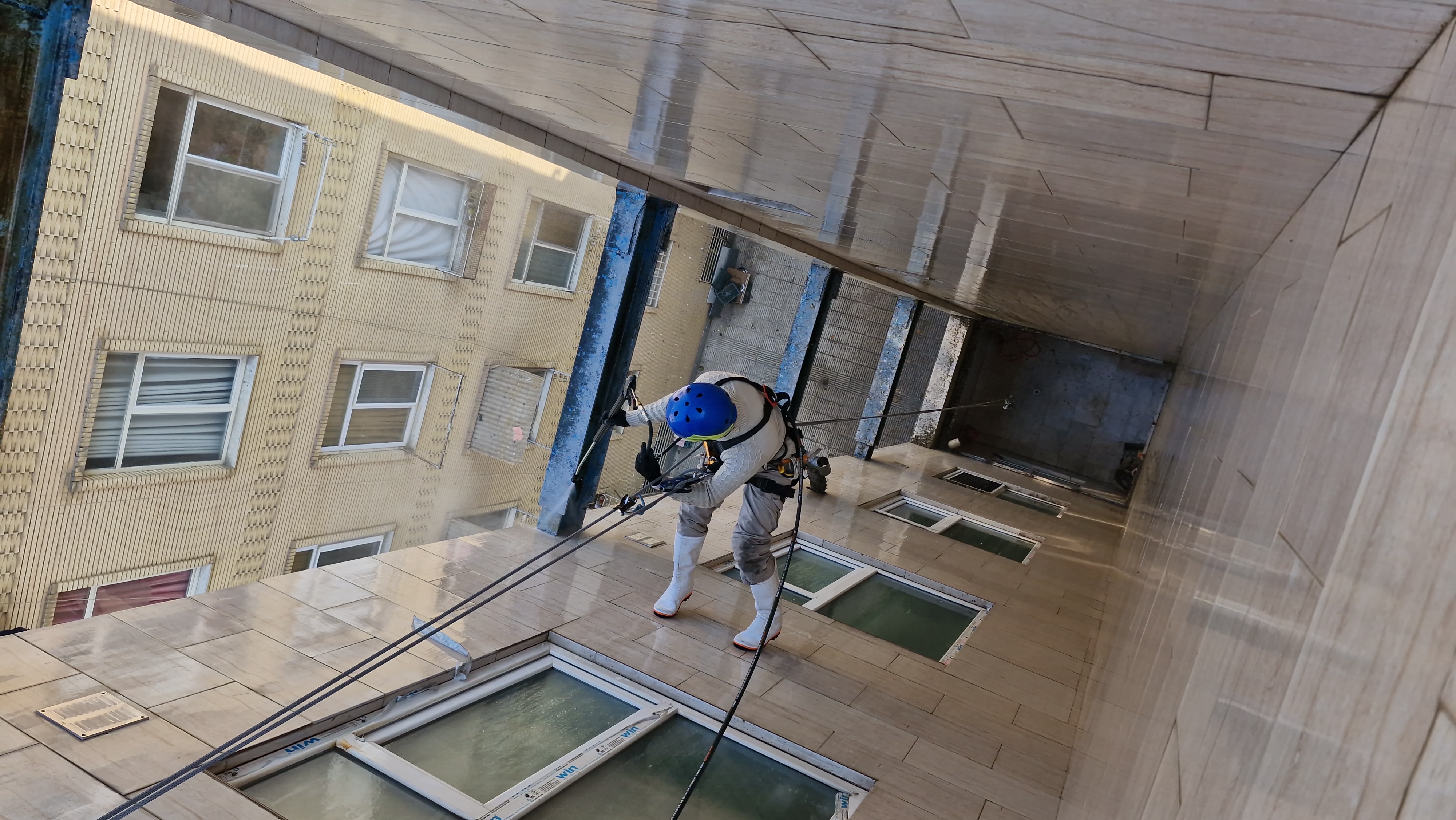  شستشوی نما و شستشوی پاسیو: راهنمای جامع و کاربردینمای ساختمان به‌عنوان بخشی از ظاهر بیرونی آن، نقش مهمی در زیبایی و ارزش ساختمان دارد. همچنین، پاسیو به‌عنوان فضایی باز یا نیمه‌باز در داخل ساختمان، مکانی برای آرامش و زیبایی است. اما آلودگی‌های محیطی، گرد و غبار، دود خودروها و لکه‌های مختلف می‌توانند به مرور زمان ظاهر این بخش‌ها را کدر و آلوده کنند. شستشوی نما و پاسیو نه تنها به زیبایی ساختمان کمک می‌کند بلکه دوام و عمر مفید آنها را نیز افزایش می‌دهد.شستشوی نماشستشوی نما شامل پاکسازی انواع سطوح خارجی ساختمان از جمله سنگ، شیشه، آجر و کامپوزیت است. این کار برای حفظ زیبایی و جلوگیری از آسیب‌های ناشی از آلودگی ضروری است.انواع روش‌های شستشوی نما1. شستشوی با آب و مواد شوینده: در این روش، از فشار بالای آب و مواد شوینده خاص برای پاکسازی آلودگی‌ها استفاده می‌شود. مناسب برای سطوحی مانند شیشه و سنگ است.2. واترجت: این روش از دستگاه‌هایی با فشار قوی آب برای تمیز کردن آلودگی‌های سخت استفاده می‌کند. مناسب برای نماهای سنگی و آجری.3. واترسندبلاست: ترکیبی از آب و شن ریز برای از بین بردن آلودگی‌های عمیق و لکه‌های سرسخت روی سطوح مختلف.4. شستشوی دستی: این روش برای سطوح حساس و جزئیات کوچک استفاده می‌شود.مزایای شستشوی نماحفظ زیبایی ظاهری ساختمانجلوگیری از آسیب‌های ناشی از آلودگی‌هاافزایش دوام مصالح ساختمانیبهبود ارزش ملک---شستشوی پاسیوپاسیو‌ها به‌دلیل ارتباط مستقیم با محیط بیرونی بیشتر در معرض آلودگی قرار دارند. شستشوی منظم آنها باعث حفظ تمیزی، ایجاد حس آرامش و جلوگیری از رشد قارچ‌ها و کپک‌ها می‌شود.مراحل شستشوی پاسیو1. جمع‌آوری زباله‌ها و برگ‌های خشک:قبل از شستشو، سطح پاسیو را از زباله‌ها و برگ‌های خشک پاک کنید.2. استفاده از مواد شوینده مناسب:بسته به نوع سطح (سنگ، سرامیک، یا بتن)، مواد شوینده مخصوص را انتخاب کنید.3. استفاده از واترجت یا دستگاه‌های مشابه:برای پاکسازی عمقی و از بین بردن لکه‌های سخت.4. شستشوی گوشه‌ها و درزها:با استفاده از ابزارهای دستی، گوشه‌ها و درزهای بین کاشی‌ها را تمیز کنید.5. خشک کردن:بعد از شستشو، سطح را خشک کنید تا از ایجاد لکه‌های آب جلوگیری شود.نکات مهم در شستشوی پاسیواز مواد شوینده‌ای استفاده کنید که به محیط زیست آسیب نمی‌زنند.برای جلوگیری از لغزش، حتما پس از شستشو سطح را کاملاً خشک کنید.شستشوی منظم (هر 3 تا 6 ماه) می‌تواند از آسیب‌های بلندمدت جلوگیری کند.---اهمیت استفاده از متخصصان حرفه‌ایشستشوی نما و پاسیو نیاز به تجهیزات و مواد خاص دارد. همچنین، در صورت وجود ارتفاع زیاد یا آلودگی‌های سرسخت، استفاده از تیم‌های حرفه‌ای ایمن‌تر و مؤثرتر است.0912487825702133570801